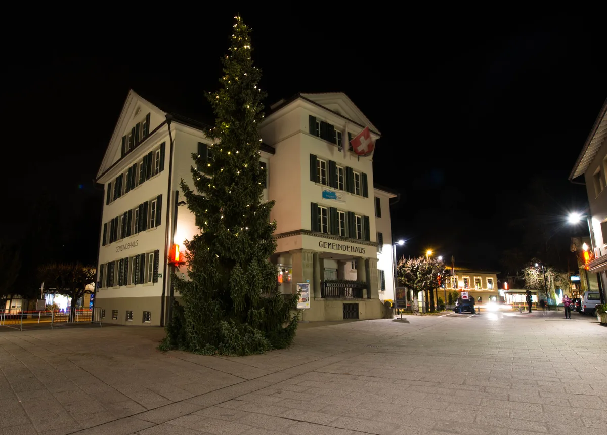 Ein Gemeindehaus. Davor steht ein Weihnachtsbaum.